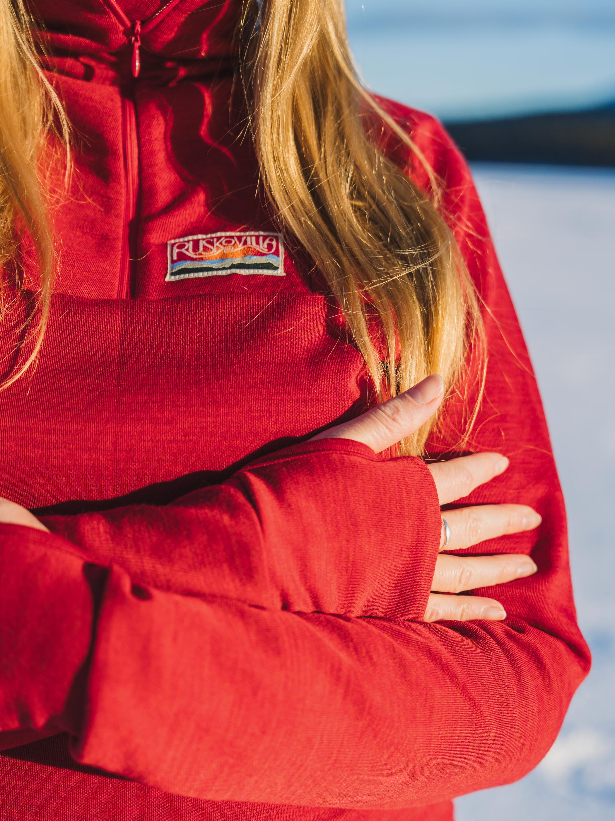 Yksityiskohta punaisen ulkoilupaidan peukalonreiällisistä hihoista.