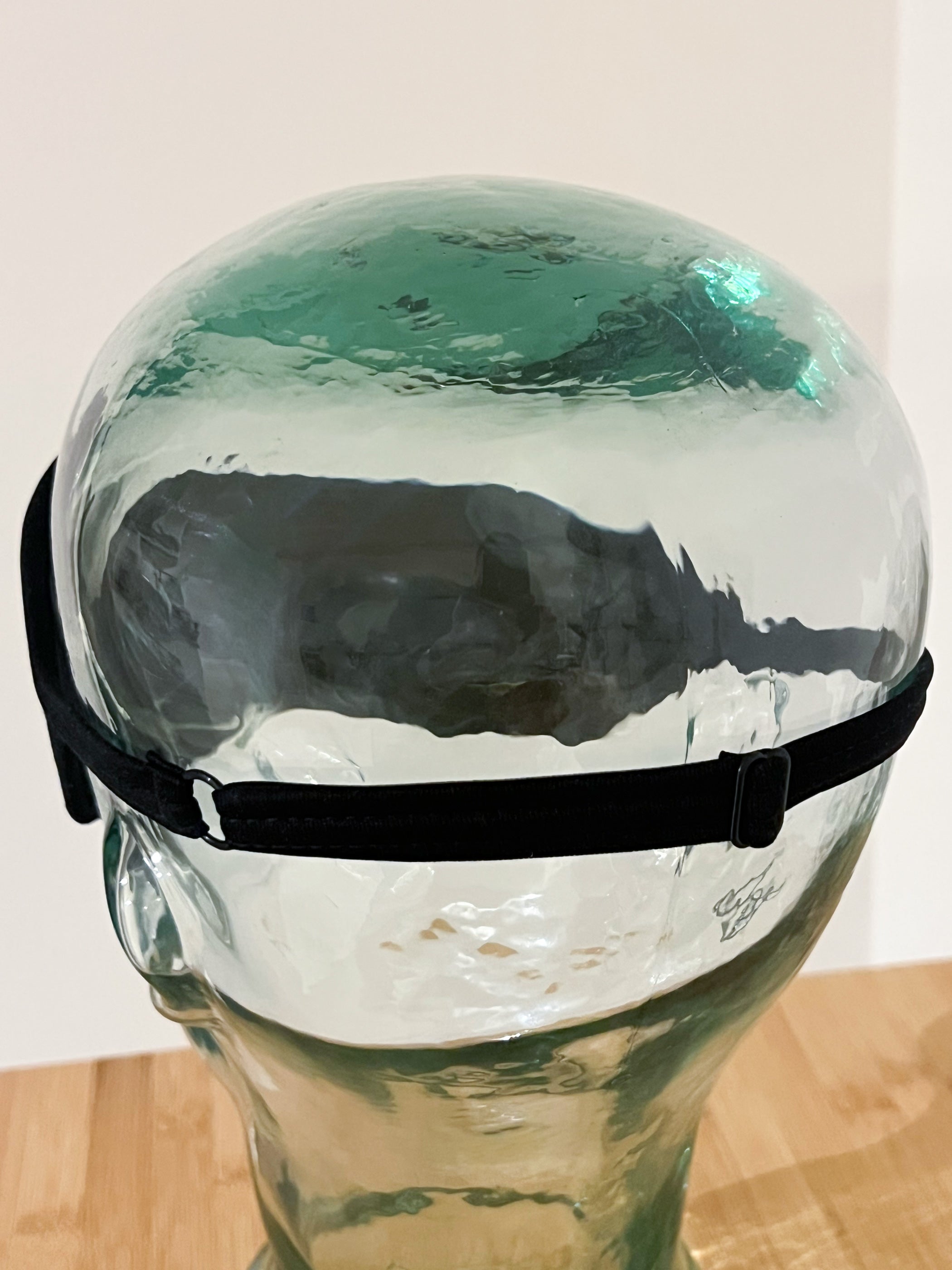 Ruskovilla yksityiskohta mustan silkkisen unimaskin säätömahdollisuudesta